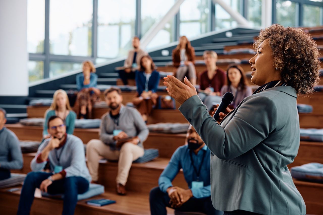 female speaker talking on a business conference at convention center